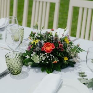 Beautiful outdoor table setting with vibrant floral centerpiece, ideal for weddings or events.
